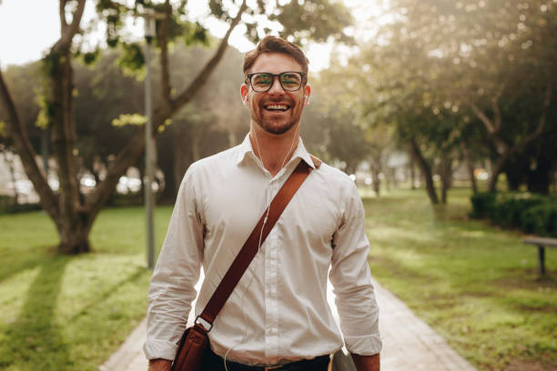 alegre empresário andando através de um parque para escritório - walking rush hour people business - fotografias e filmes do acervo