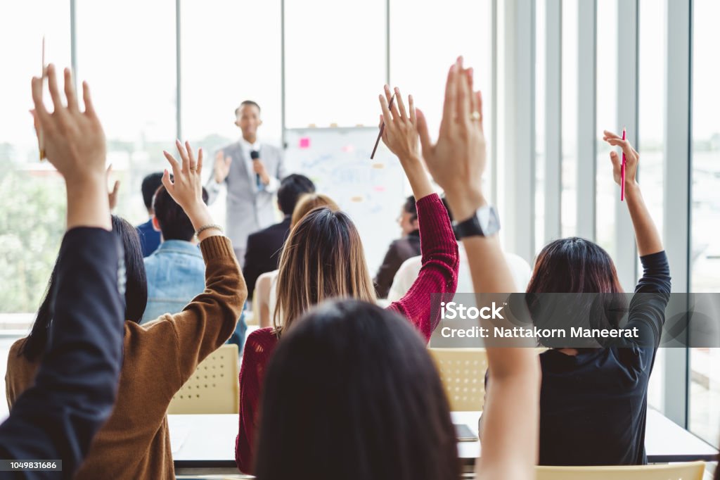 Group of business people raise hands up to agree with speaker in the meeting room seminar Question Mark Stock Photo