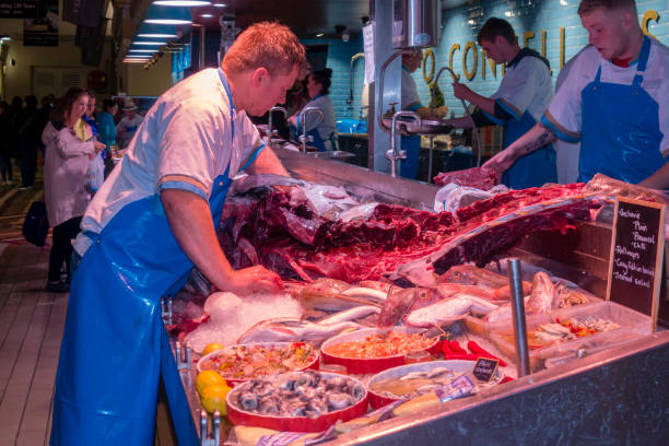 Cork, Ireland - August 11, 2018: Huge tuna with 180kg is being cutted in pieces at seafood market in Cork.
