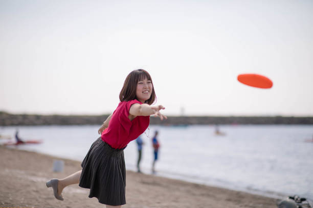 istock Young woman throwing flying disc on beach 1049832892