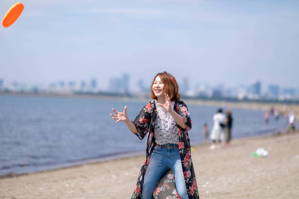 istock Young woman plying flying disc on beach 1049832922