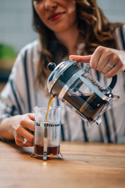 istock Midsection Of Woman Pouring Coffee In Glass Container On Table 1049840574