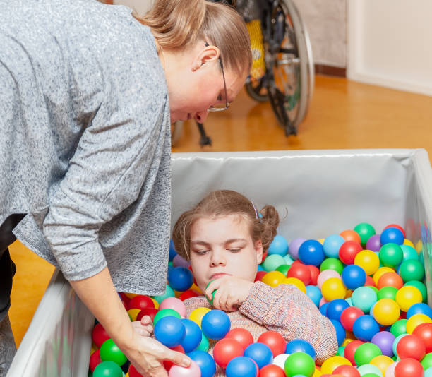 istock Disability a disabled child enjoying play therapy together with a special needs carer 1049844008