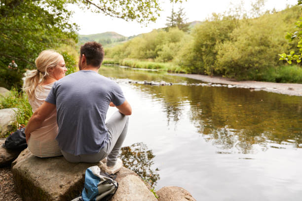 istock Couple On Hike Looking Out Over River In UK Lake District 1049852910