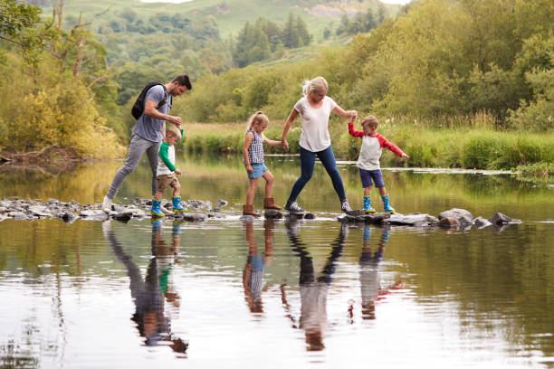 familia cruzando río y senderismo en lagos del reino unido - familia con tres hijos fotografías e imágenes de stock