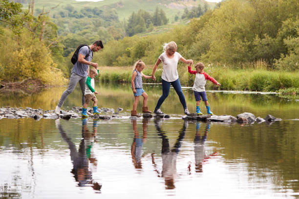 rio de cruzamento de família enquanto caminhadas no distrito de lake, uk - cumbria - fotografias e filmes do acervo