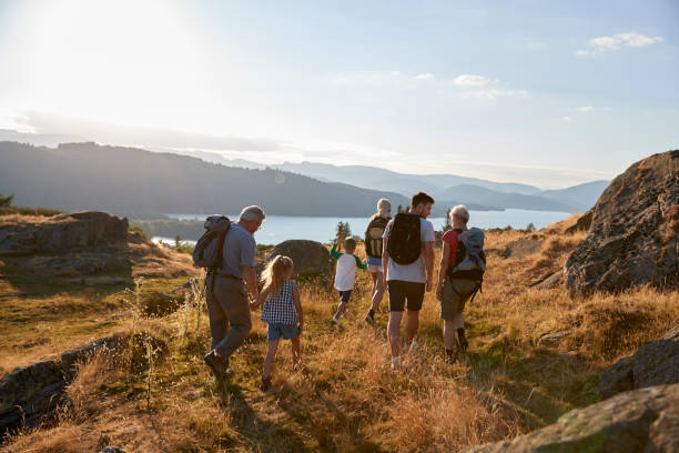 rückansicht des multi-generationen-familie zu fuß auf hügel auf wanderung durch die landschaft im lake district uk - family grandmother multi generation family nature stock-fotos und bilder