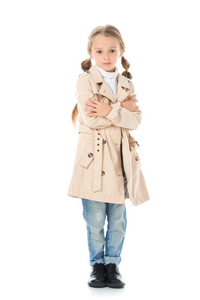 istock adorable child posing in beige coat, isolated on white 1049863284