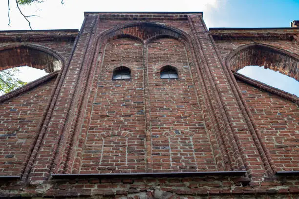 Photo of An old church in Central Europe. A religious building of red brick worship. Season of the autumn.