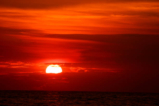 istock last light sunset on  sky orange cloud ray around sun over sea 1049873772
