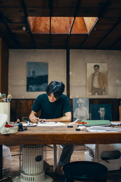 istock Mature male artist sketching ideas at a table in his studio 1049885046