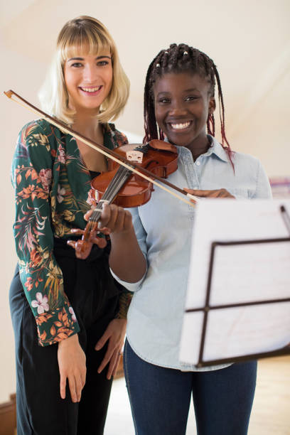 retrato de mujer alta maestro con alumno tocar violín en lección de música - practicing music violin women fotografías e imágenes de stock