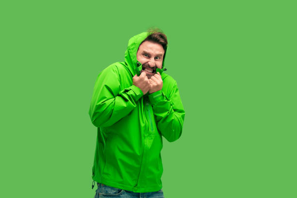 istock handsome bearded young man looking at camera isolated on green 1049888204