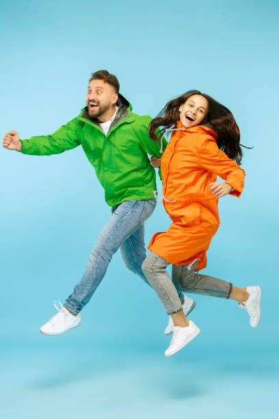 istock The young surprised couplel posing at studio in autumn jackets isolated on blue 1049888504