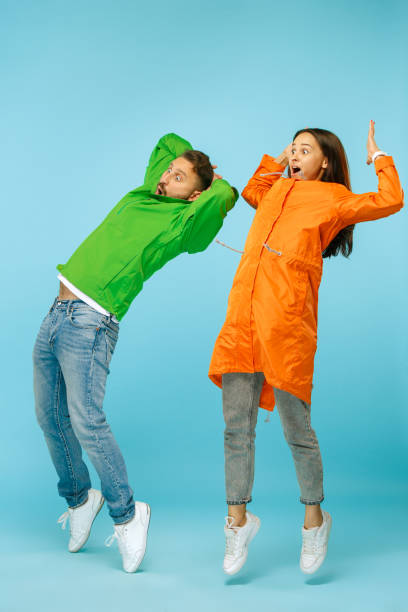 istock The young surprised couplel posing at studio in autumn jackets isolated on blue 1049888538