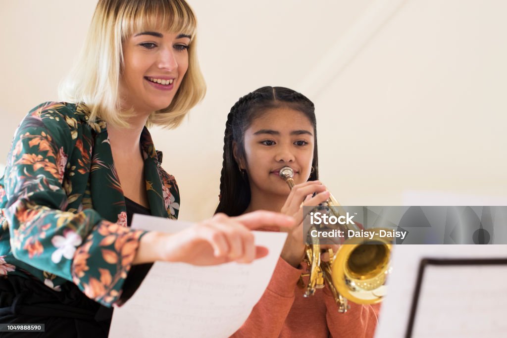 Teacher Helping Female Student To Play Trumpet In Music Lesson Music Stock Photo