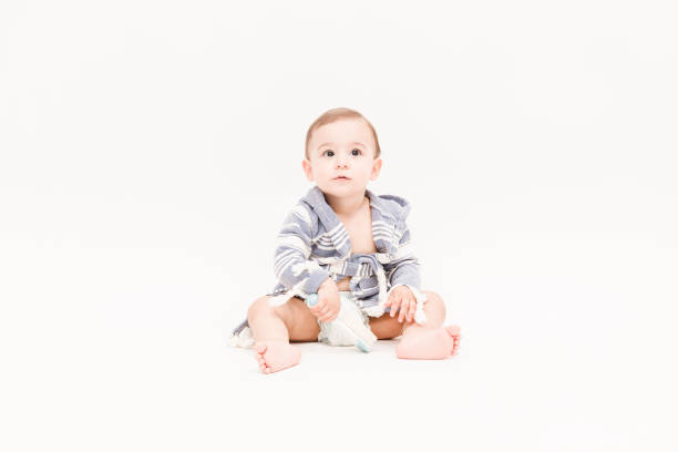 istock Happy baby boy is sitting on white background 1049897970