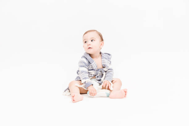 istock Happy baby boy is sitting on white background 1049897990