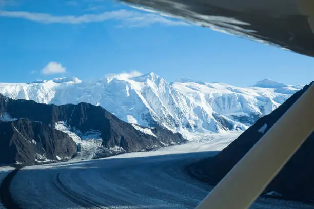 Bush plane wing looking out over the Matanuska Glacier and the Chugach Mountains where it originates. The tallest peak on the right is Mt Marcus Baker