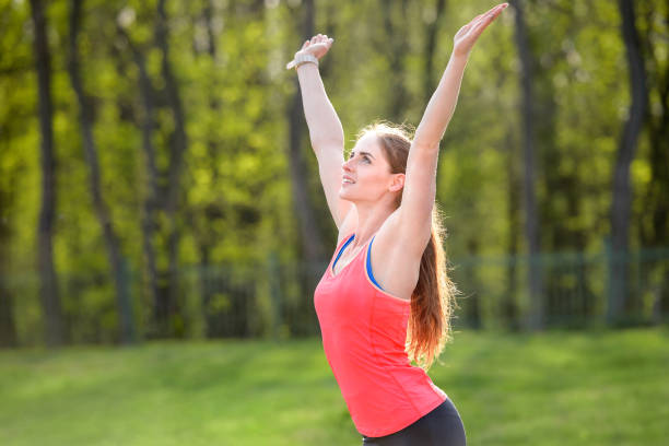 istock A girl runner smiling raised her hands up in the park 1049912700