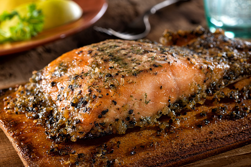 A serving of delicious maple and smoked pepper cedar planked salmon.