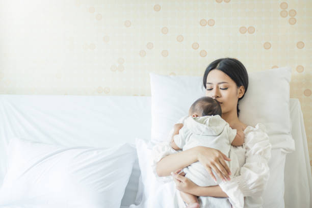 Close up portrait of beautiful young asian mother with newborn baby Close up portrait of beautiful young asian mother with newborn baby, copy space with bed in the hospital. Healthcare and medical love lifestyle mother's day concept arab culture photos stock pictures, royalty-free photos & images