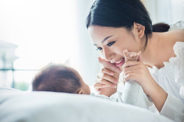 ręce matki trzymające nowo narodzone stopy dziecka. - baby newborn chinese ethnicity asian ethnicity zdjęcia i obrazy z banku zdjęć