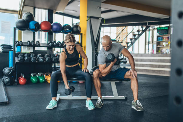 istock Fitness trainer teaching woman weightlifting 1049932234