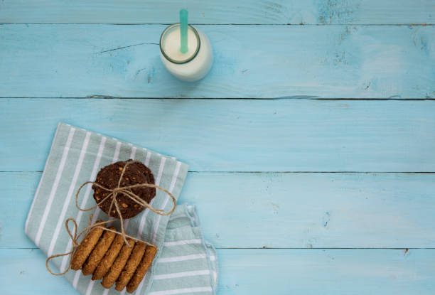Milk bottle and cookies on wood background