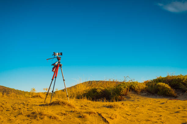 istock Camera on sand beach taking picture film 1049941700