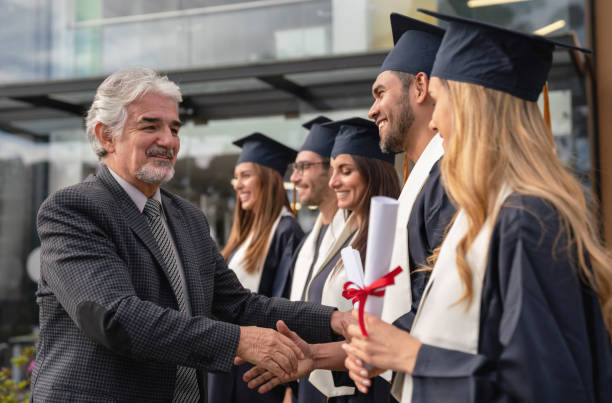 istock Teacher congratulating a group of students on graduation day 1049942650