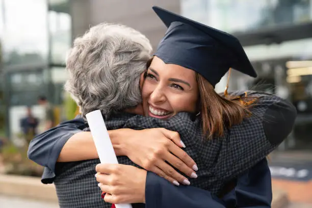 Photo of Happy student hugging her father and celebrating her graduation
