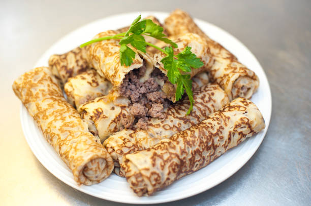 istock Pancakes with minced meat and greens on a white plate 1049949994