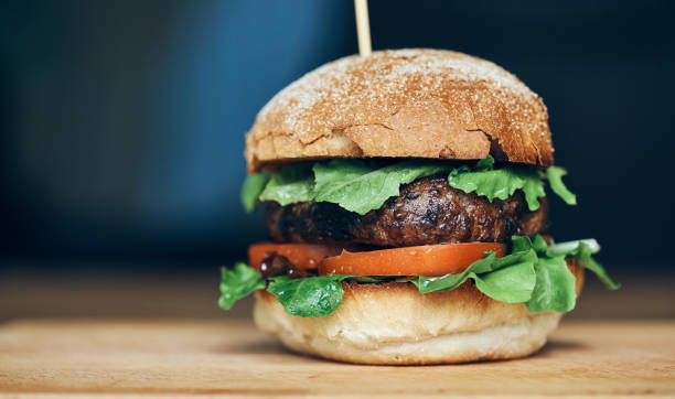 istock A beef burger in a crusty bun with lettuce and tomatoes 1049959044