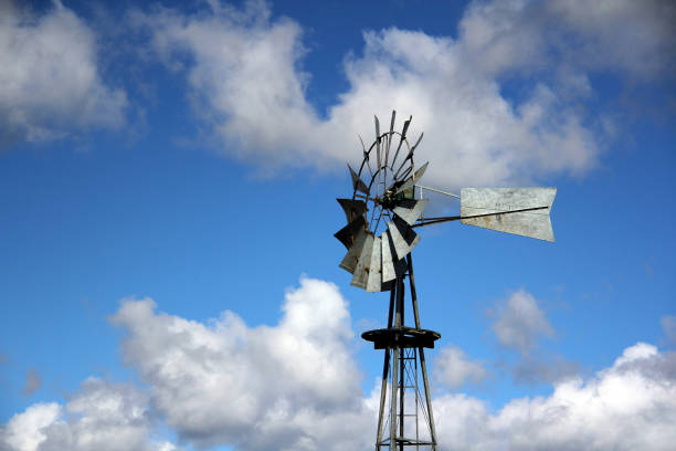 istock View of An Old-style Windmill Against A Sun and Cloud Blue Sky 1049959966
