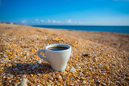 cup of cofee on a sandy sea beach