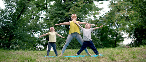 istock Family Practicing Yoga For Happiness in Nature 1049973000