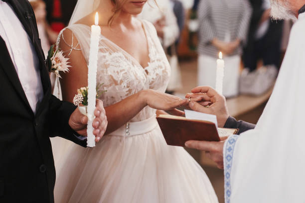 padre colocando em ouro anel de casamento no dedo da noiva. matrimônio de casamento na igreja. trocando alianças - orthodox orthodox church christianity church - fotografias e filmes do acervo