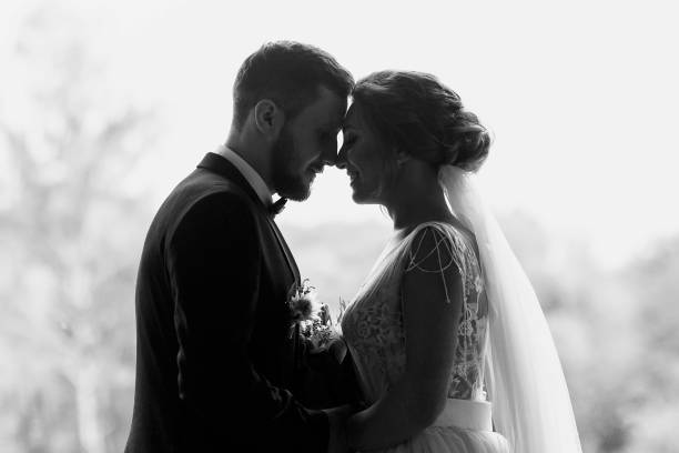 gorgeous bride and stylish groom silhouettes at window light. sensual wedding couple embracing. romantic moments of newlyweds. creative wedding photo. copy space - photography wedding bride groom imagens e fotografias de stock