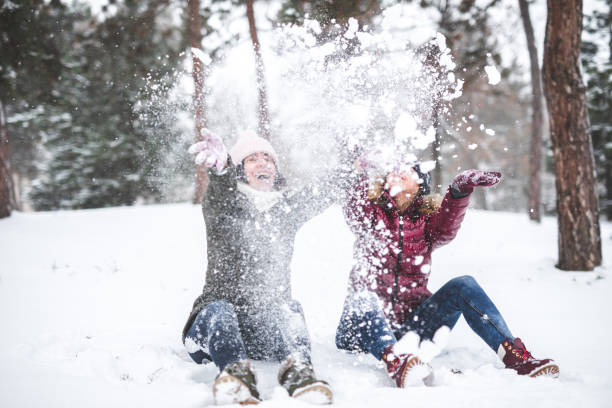 istock Two young women throwing snow 1049997600