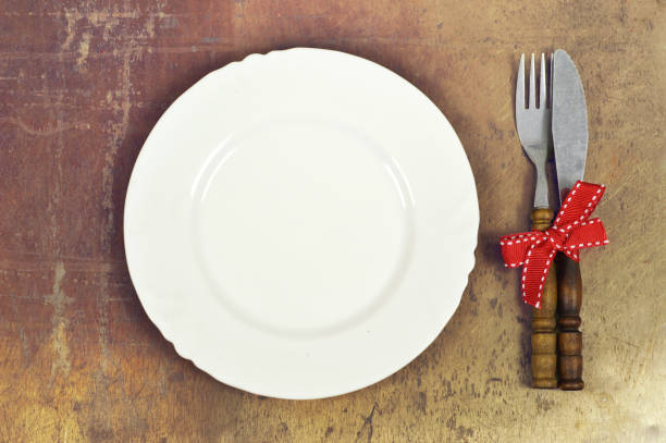 istock Festive table setting. Plate and cutlery tied with red ribbon 1050000544
