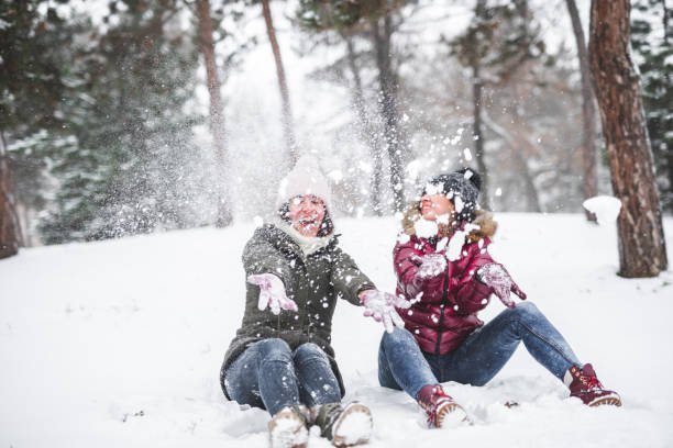 istock Two young women throwing snow 1050000836