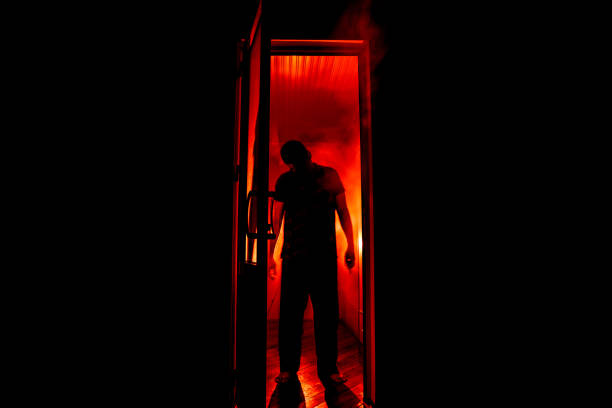 silueta de una figura de sombra desconocida en una puerta a través de una puerta de vidrio cerrada. la silueta de un ser humano frente a una ventana por la noche. concepto de escena de miedo halloween - spooky fotografías e imágenes de stock