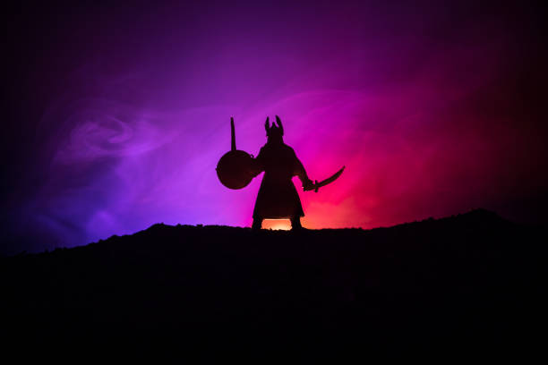 istock Fighter with a sword silhouette a sky. Medieval knight with sword. Selective focus 1050006544