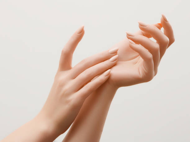 特寫圖像的美麗的女人的手與輕粉紅色的指甲指甲。皮膚護理的手, 指甲和美容治療。優雅而優雅的手, 纖細優雅的手指 - 潤手霜 個照片及圖片檔