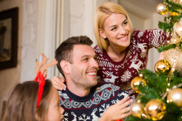 istock Young couple decorating Christmas tree with daughter 1050013116