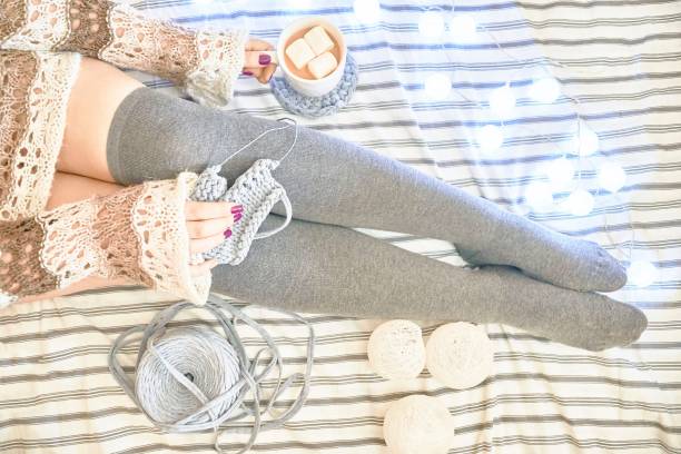 istock A woman on the bed knits a scarf. 1050013302