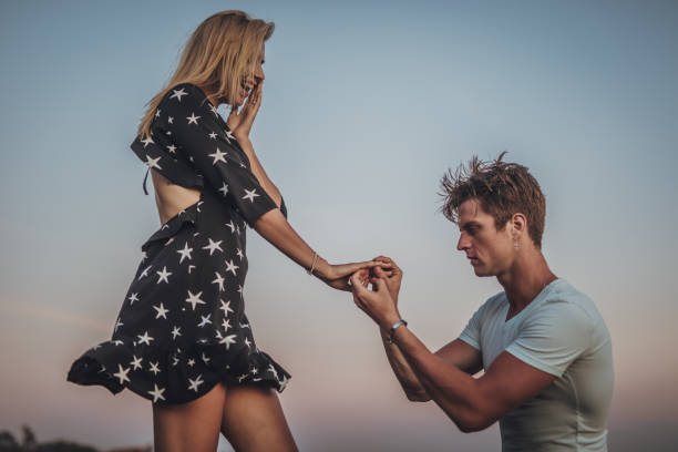 istock Man on one knee proposing to his girlfriend 1050018976