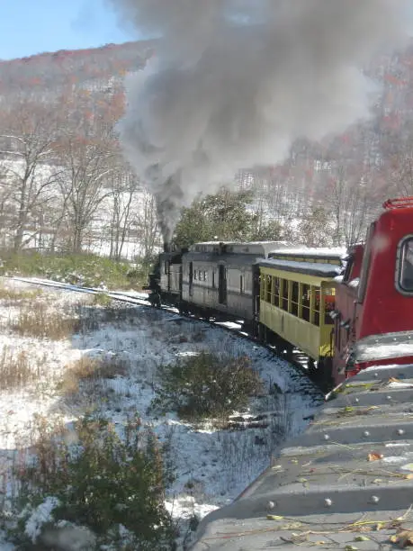 A vertical shot of a steam engine train as it drives through the West Virginia mountains in the winter.  Image taken from the cupola of the caboose.