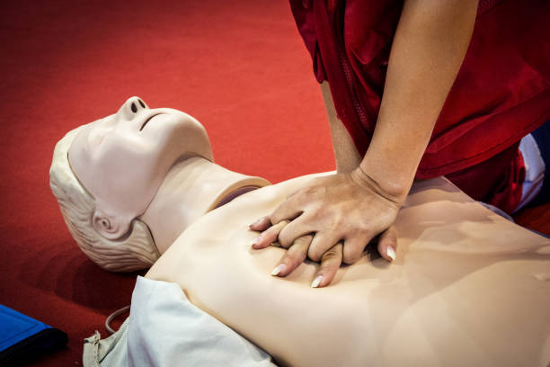 CPR demonstration - first aid class Female paramedic demonstrating CPR first aid technique on CRP dummy in class. cardio pulmonary stock pictures, royalty-free photos & images